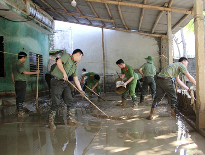 Công an dầm mình trong bùn lầy giúp người dân khắc phục hậu quả lũ lụt